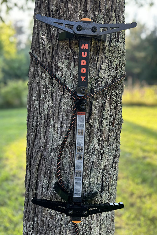 Muddy Pro climbing stick mounted on a tree in a yard.